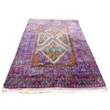 A Persian rug with blue ground, unusual sectional orange and green medallion to the field, blue
