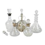 A group of cut glass decanters, three with silver collars, one a cut crystal three ring ship's style
