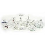 A group of Swarovski crystal animal figurines, comprising a large cat and three small cats, a