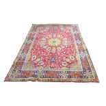 A large Tabriz rug, with central circular medallion within a red field of stylised flowers, with