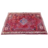 A Hamadan rug, with red ground and floral decoration, 280 by 193cm.