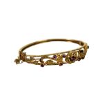 A 9ct gold floral bangle, a yellow gold oval form hinged bangle, open work textured detail set