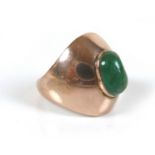 A gold and green stone dress ring, with central oval cabochon, a/f worn to one side, within a wide