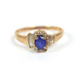 An 18ct gold blue sapphire and diamond sapphire cluster ring, the oval cut sapphire 4 by 4.5mm, with