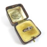 An 18ct gold diamond crossover ring, with two round cut diamonds, each 2mm diameter, flanked by