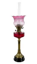 A Victorian paraffin lamp, with rose glass reservoir on a brass column, etched rose pink gradient