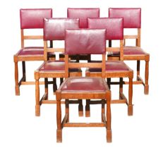 A set of six oak dining chairs, mid 20th century, with burgundy leatherette seats and backs,