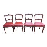 A set of four Edwardian mahogany dining chairs, with red leather upholstered seats, carved top and