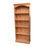 A modern pine bookcase, closed back, plinth base.