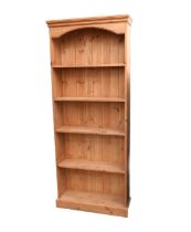 A modern pine bookcase, closed back, plinth base.