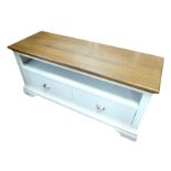 A modern TV cabinet, painted grey with wooden surface, two drawers, plinth base, 129 by 46 by 60cm