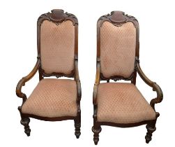 A pair of mid Victorian mahogany open arm chairs, with carved top rail, padded back and seat,