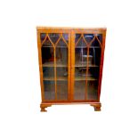 A glass fronted bookcase with two doors, three shelves, with a lock and key. 84 by 30.4 by 117cm.