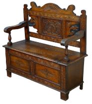 An Edwardian carved oak monk's bench, with lift lid storage in seat, 106.5 by 42.5 by 105cm high.