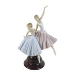 A large Lladro figurine 'Merry Ballet', modelled as two ballerinas, raised on a circular wooden