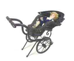 A Victorian style doll's pram, woven wicker painted black, together with a modern bisque headed