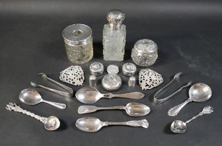 A collection of silver items, comprising various spoons, three silver topped cut glass dressing