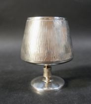 A contemporary design silver goblet, with bark textured body, raised on a circular foot, with gilt