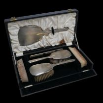A George VI cased associated set of silver backed dressing table brushes, comprising four hand