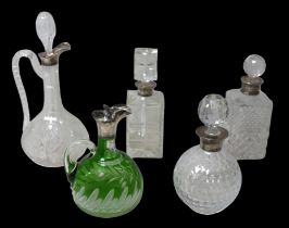 Five Edwardian and later silver mounted claret jugs and decanters, including a bohemian glass claret