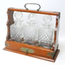 A 20th century oak cased Tantalus, with three glass decanters, 35 by 15.7 by 31cm high.