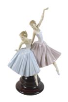 A large Lladro figurine 'Merry Ballet', modelled as two ballerinas, raised on a circular wooden