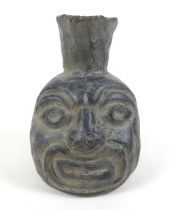 A Pre-Colombian or later black ware mask vessel, 12 by 18cm high.