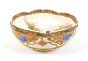 A Japanese Satsuma ware bowl, hand painted with two ladies in a garden, with piped detail and gilt