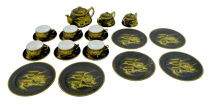 A Maruki china tea service, decorated in gilt against a black ground with a mountainous landscape