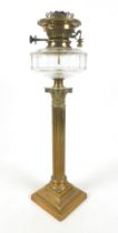 A clear glass and brass paraffin lamp, with fluted Corinthian column support, clear glass faceted