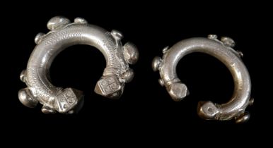 Two Persian metal 'anklets', with stamped and applied decoration, larger anklet measured 9.5cm