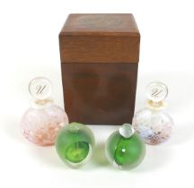 A group of four unusual glass perfume bottles, two green and gold prototypes, and two mottled