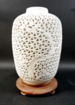 An Oriental reticulated china lamp, on a circular wooden base, 36cm high.