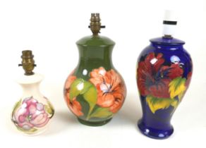 A group of three Moorcroft lamps, including a baluster form vase in the pattern 'Magnolia', a/f,