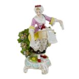 A Derby porcelain figurine, early 19th century, modelled as a music seller, the lady in a pink and