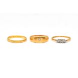 A GOLD AND PLATINUM DIAMOND THREE STONE RING AND TWO FURTHER GOLD RINGS (3)