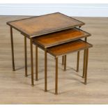 A NEST OF THREE MID-20TH CENTURY LEATHER INSET LACQUERED BRASS OCCASIONAL TABLES (3)