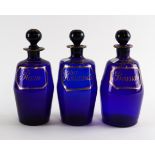 THREE BLUE GLASS SPIRIT DECANTERS AND STOPPERS