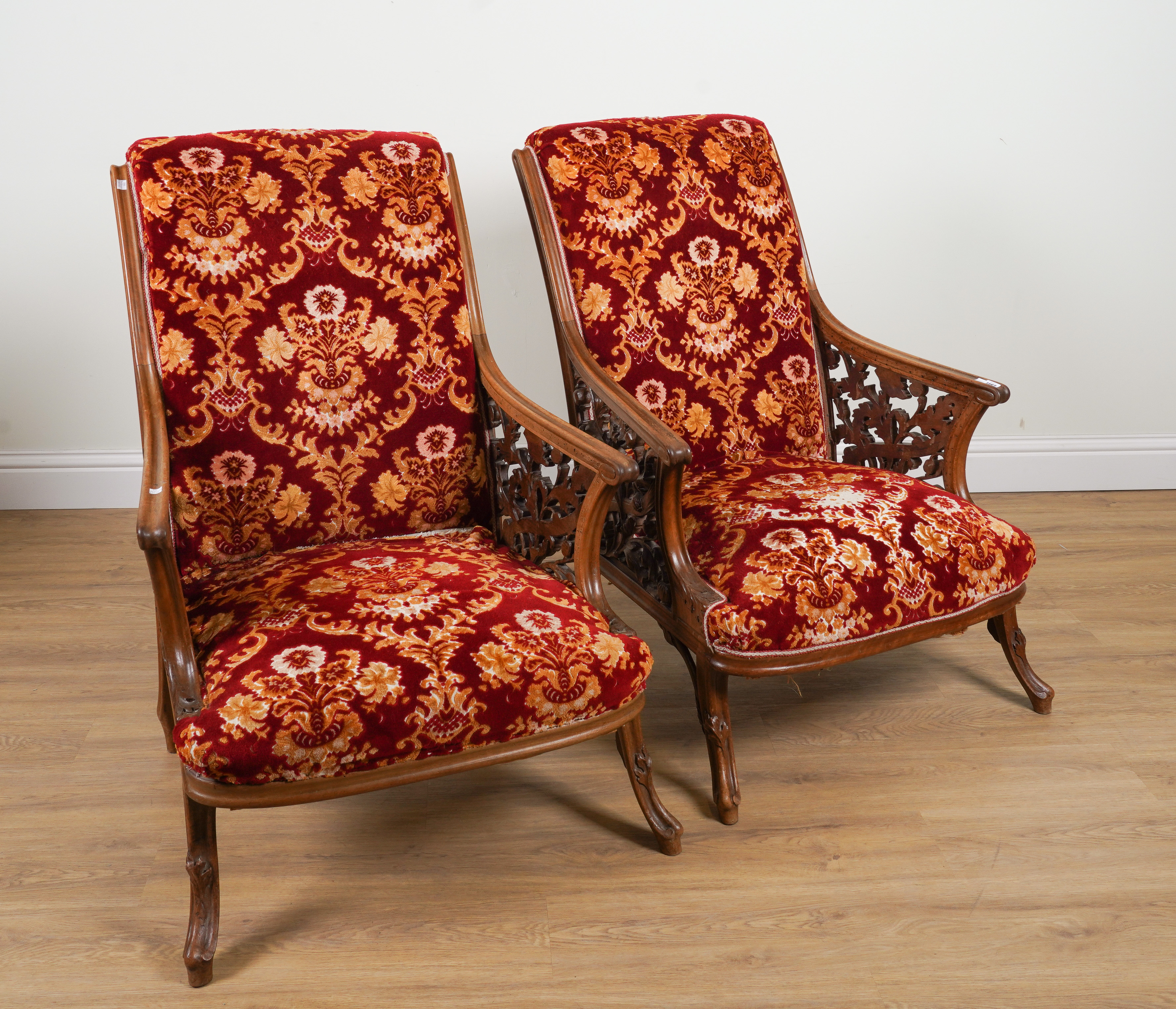 A PAIR OF EARLY 20TH CENTURY MAHOGANY FRAMED OPEN ARMCHAIRS WITH CARVED AND PIERCED FOLIATE...