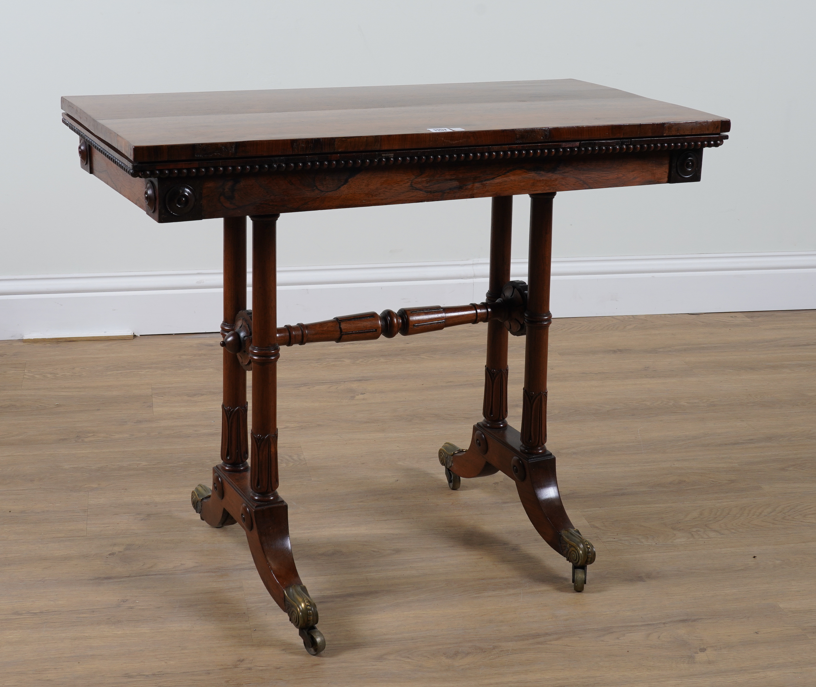 A WILLIAM IV ROSEWOOD RECTANGULAR FOLD-OVER GAMES TABLE ON TULIP CARVED SUPPORTS