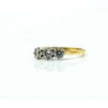 AN 18CT GOLD AND DIAMOND THREE STONE RING