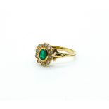 AN 18CT GOLD EMERALD AND DIAMOND OVAL CLUSTER RING