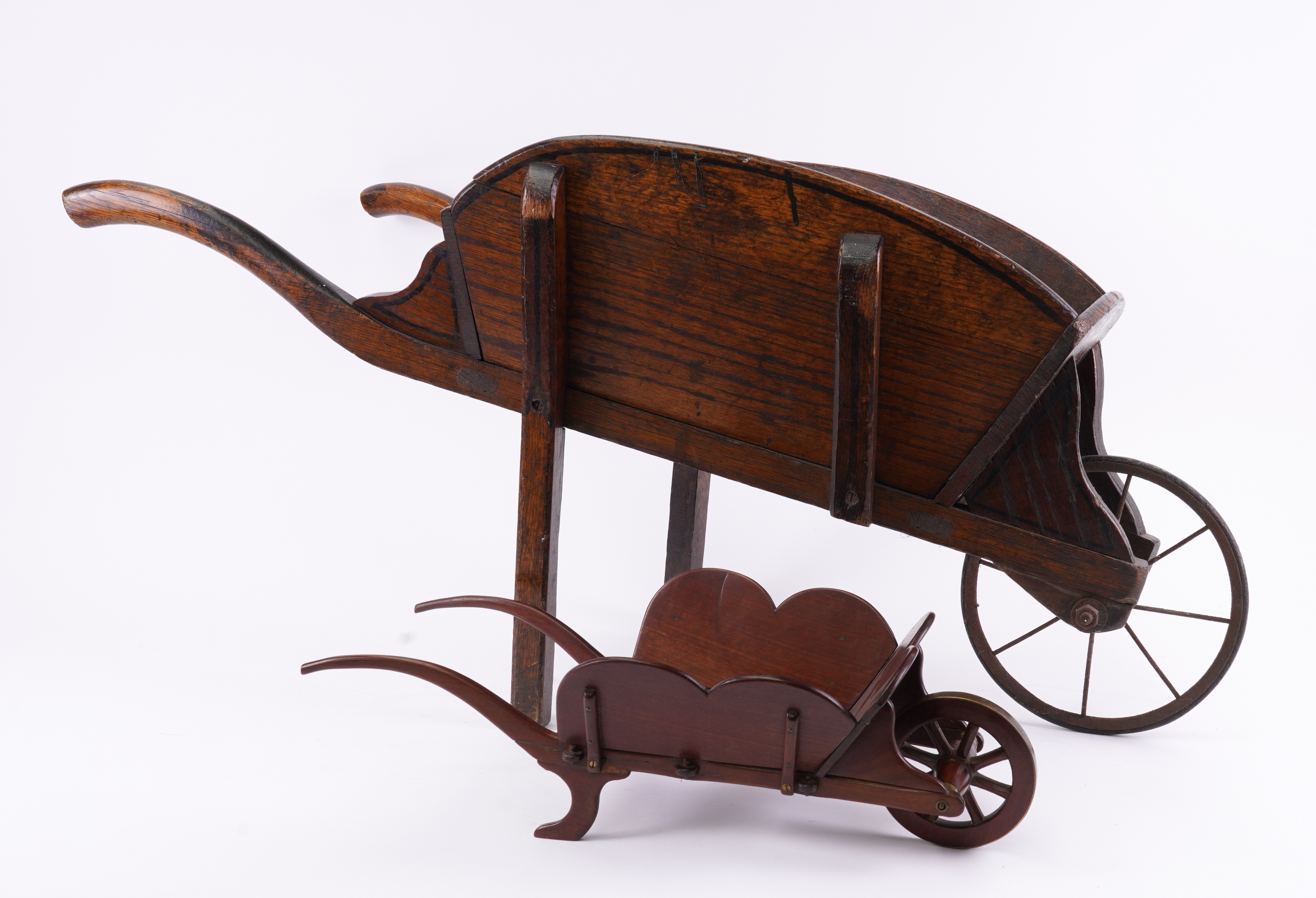 A LATE VICTORIAN MAHOGANY AND BRASS MOUNTED TABLE WHEEL BARROW AND AN ELM CHILD’S WHEEL BARROW...