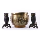 A PAIR OF CAST-IRON ‘OWL’ ANDIRONS AND A BRASS LOG BIN (3)