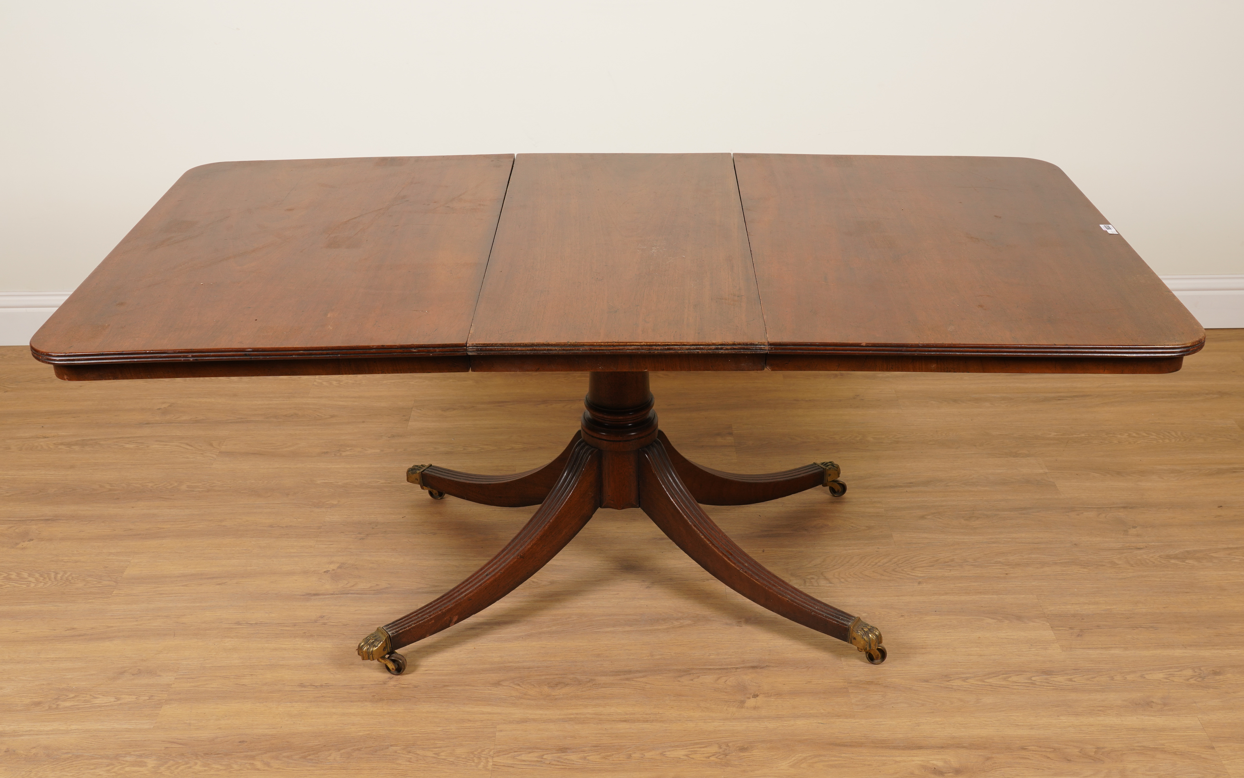 A GEORGE III MAHOGANY SINGLE PEDESTAL EXTENDING DINING TABLE