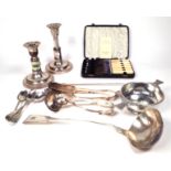 SILVER PLATED WARES, INCLUDING A PAIR OF CANDLESTICKS, A LADLE, TEASPOONS AND FURTHER ITEMS