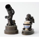 A BRONZE WINGED CHERUB DESK STAND AND A CHERUB VESTA STRIKER (2)