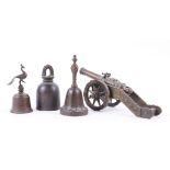 A BRONZE TABLE CANNON TOGETHER WITH THREE BRONZE TABLE BELLS (4)