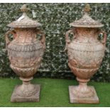 A PAIR OF SWEDISH STYLE COMPOSITION STONE LIDDED TWIN HANDLE URNS (2)