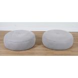 A PAIR OF GREY UPHOLSTERED CIRCULAR FOOT STOOLS (2)